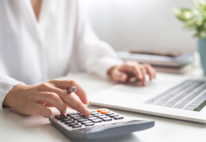 Hände nutzen Taschenrechner neben Notizen zur CO2-Preis-Berechnung beim Gas.