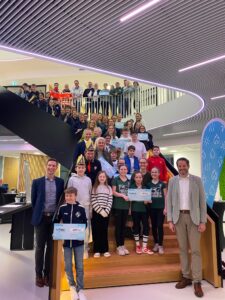 Große Gruppe von Gewinnern und Stadtwerke-Vertretern im modernen Innenraum